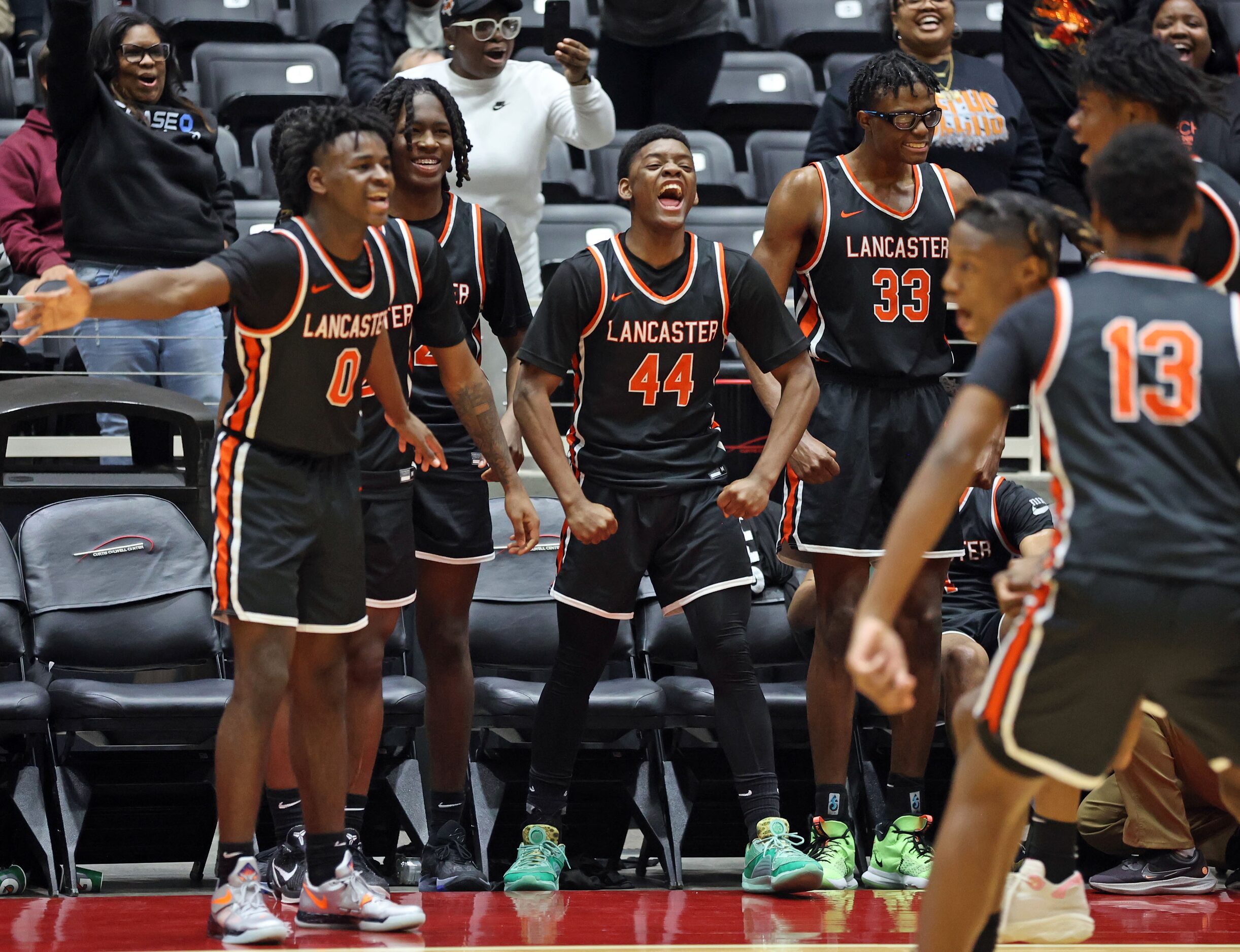 Lancaster players, including Des'meon Jones (0), Clyde' Darrious Hall (44), Amari Reed (33)...