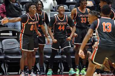 Lancaster players, including Des'meon Jones (0), Clyde' Darrious Hall (44), Amari Reed (33)...