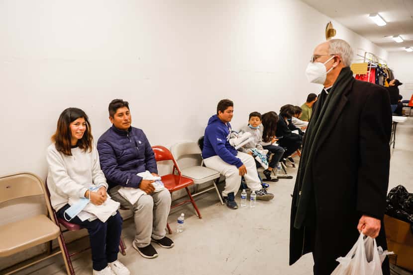 El obispo Mark Seitz habla con Alex y su hija Yaritza, de 15 años, ambos migrantes del Perú,...