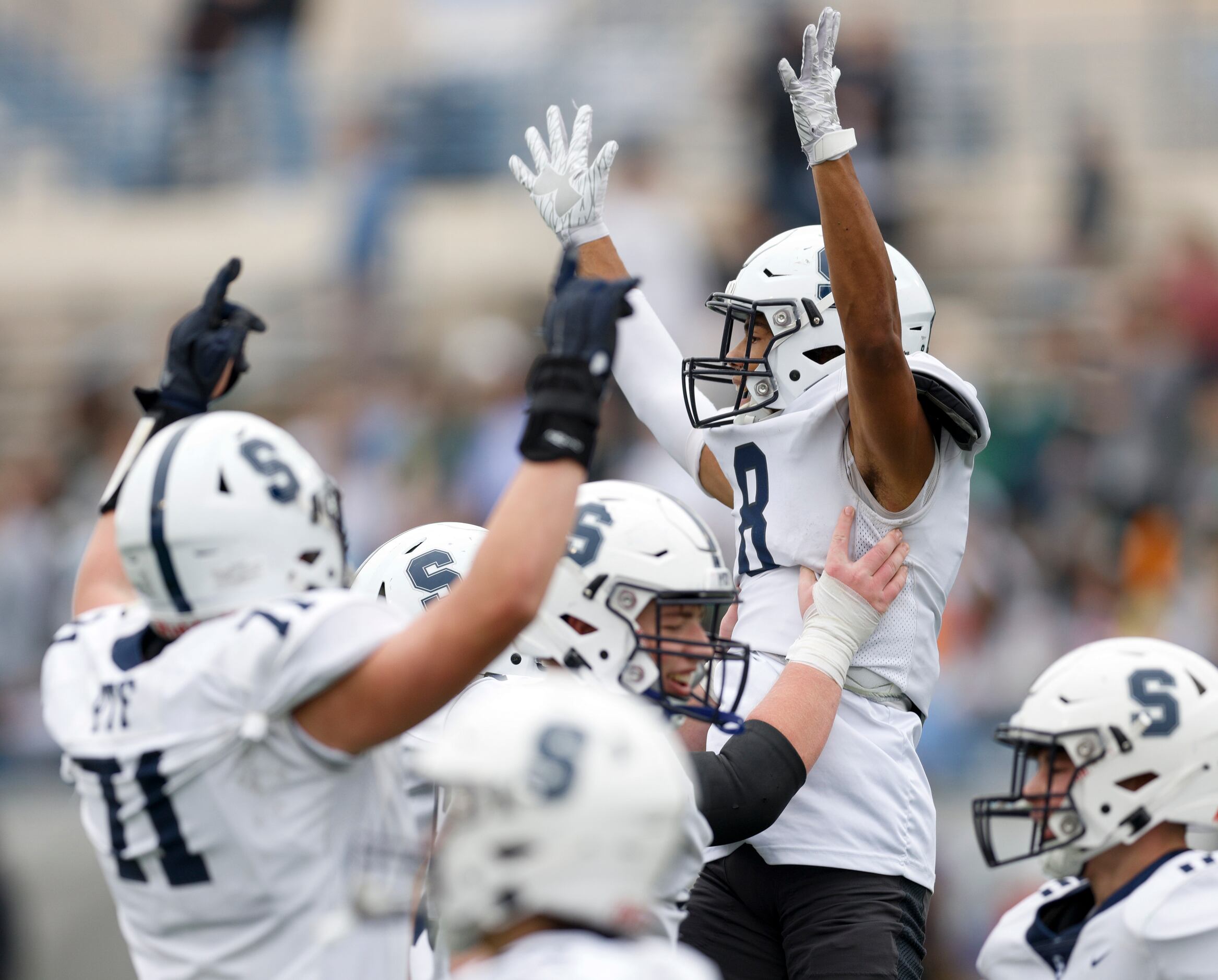 Fort Worth All Saints players celebrate a touchdown with wide receiver Christopher...