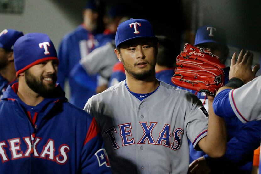 Texas Rangers starting pitcher Yu Darvish is greeted in the dugout after the end of the...