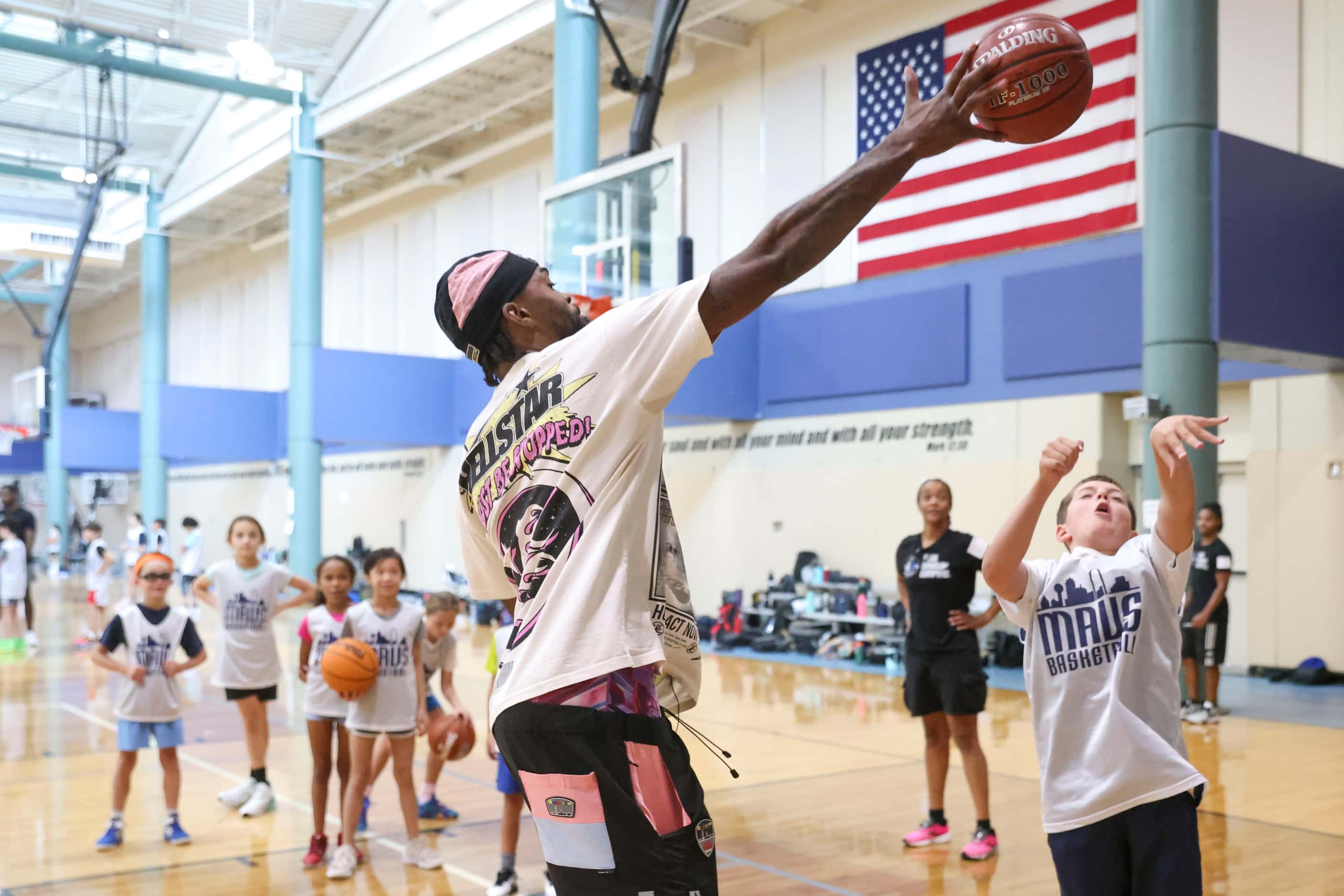 Dallas Mavericks’ Naji Marshall, blocks a shot as he plays ball with young basketball...