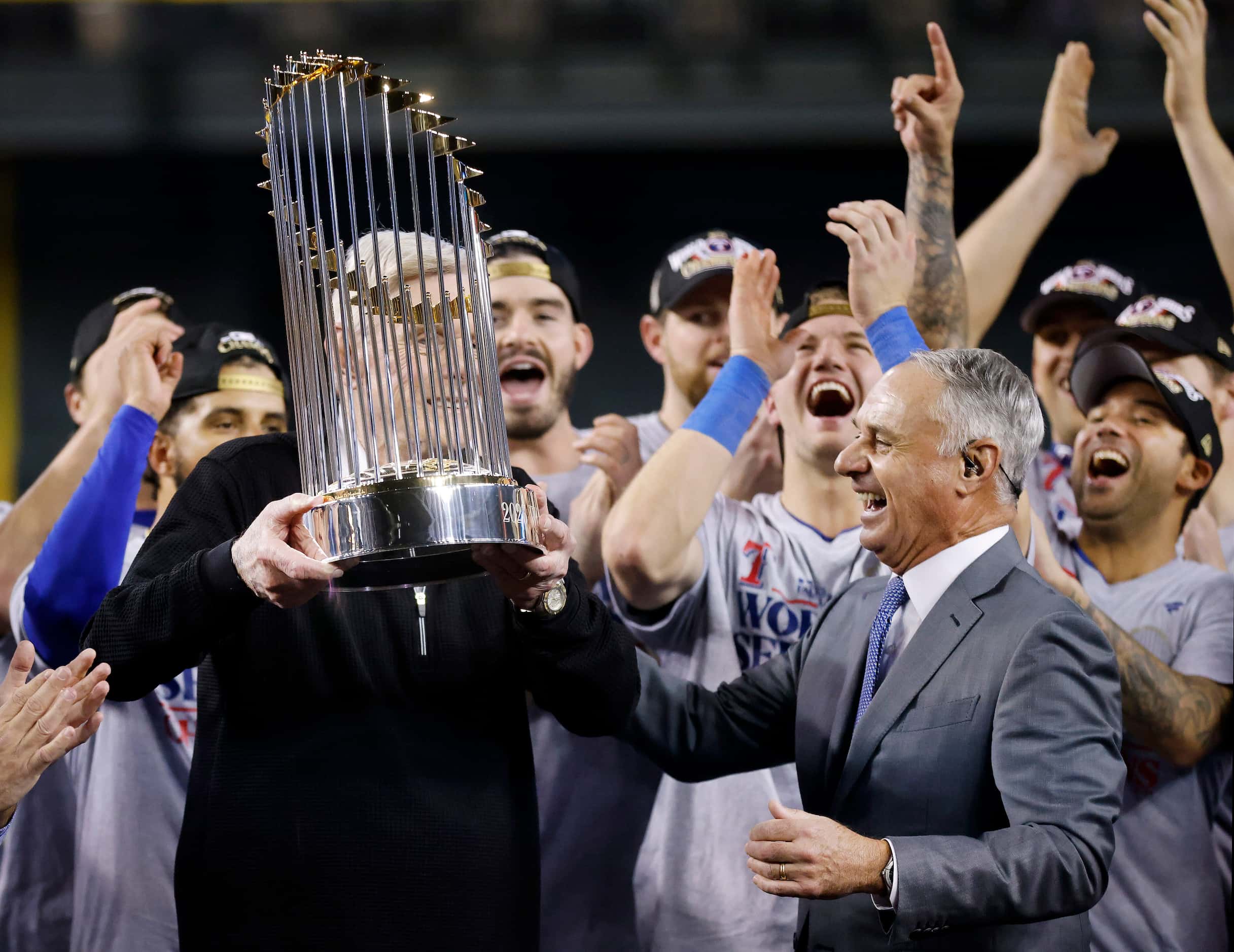 Texas Rangers co-owner Ray Davis is handed the World Series trophy by MLB Commissioner...