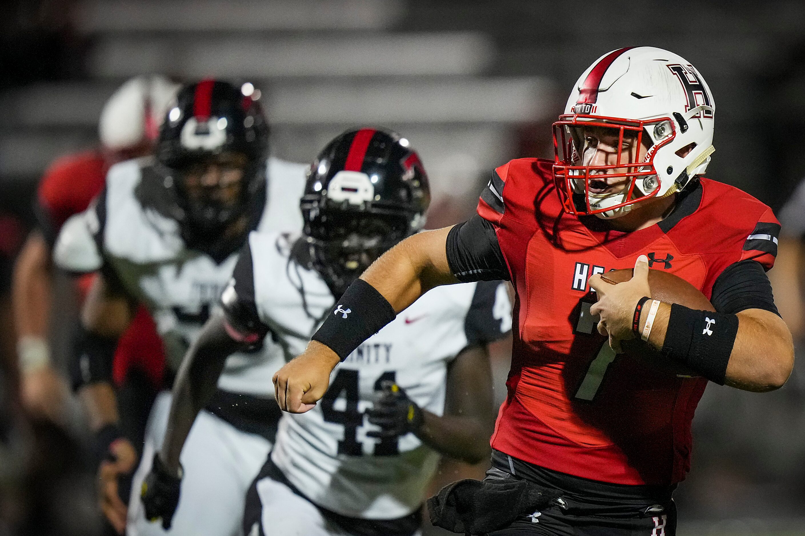 Rockwall-Heath quarterback Caleb Hoover (7) scrambles away from the Euless Trinity defense...