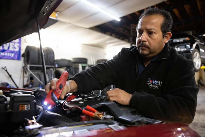 Joaquin Godinez services a car at his auto repair shop in southeast Dallas. He now has...