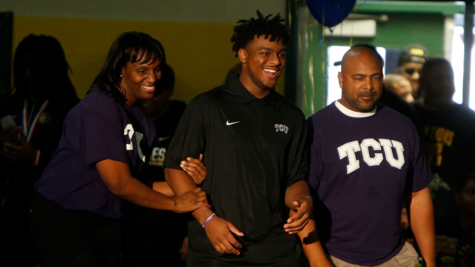 Quarterback Shawn Robinson (middle), who signed with TCU, is introduced with his parents...