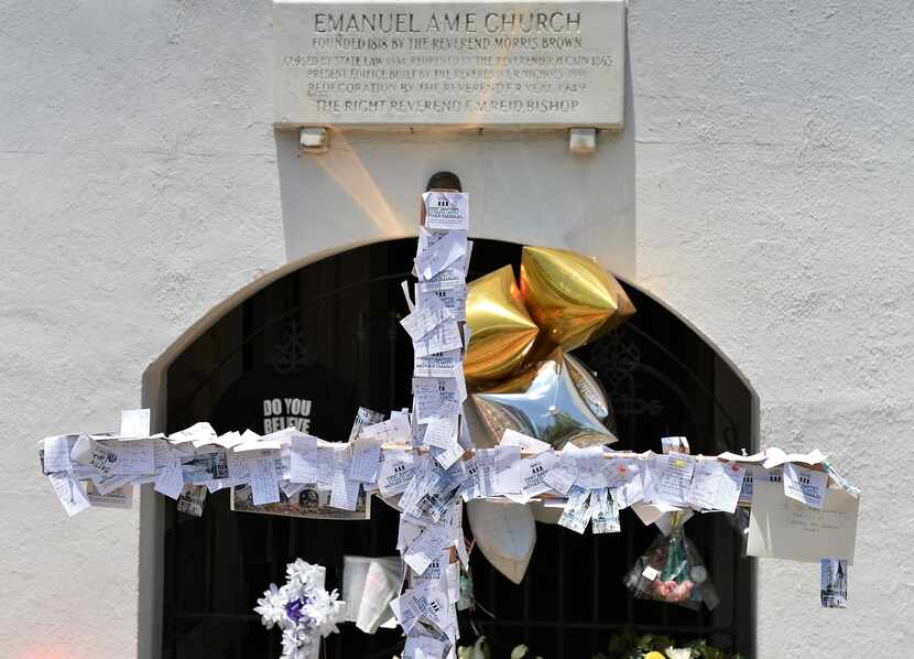 A cross covered with paper notes is erected outside the Emanuel AME Church in Charleston,...