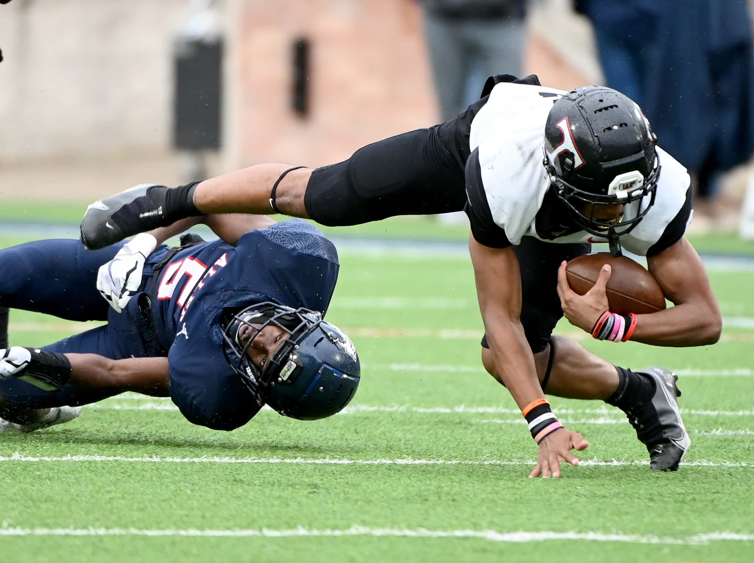 Euless Trinity's Ollie Gordon (2) is tackles by Allen's Sign Shuva (5) in the first half of...