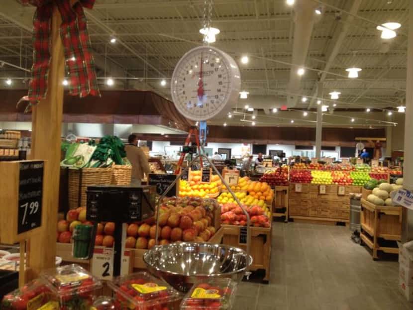 
Workers stocked The Fresh Market’s produce section in preparation for its opening...
