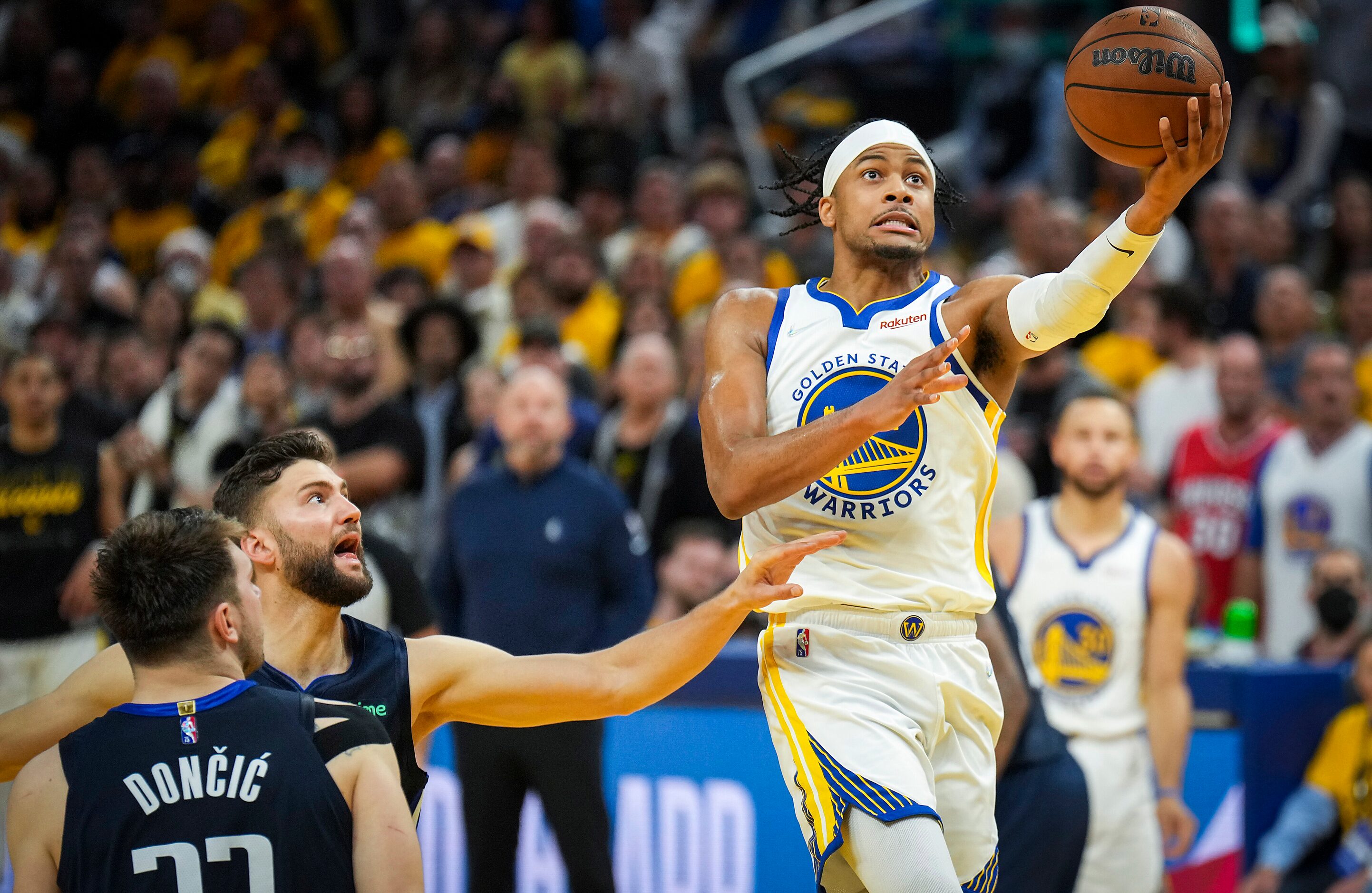 Golden State Warriors guard Moses Moody (4) scores past Dallas Mavericks guard Luka Doncic...