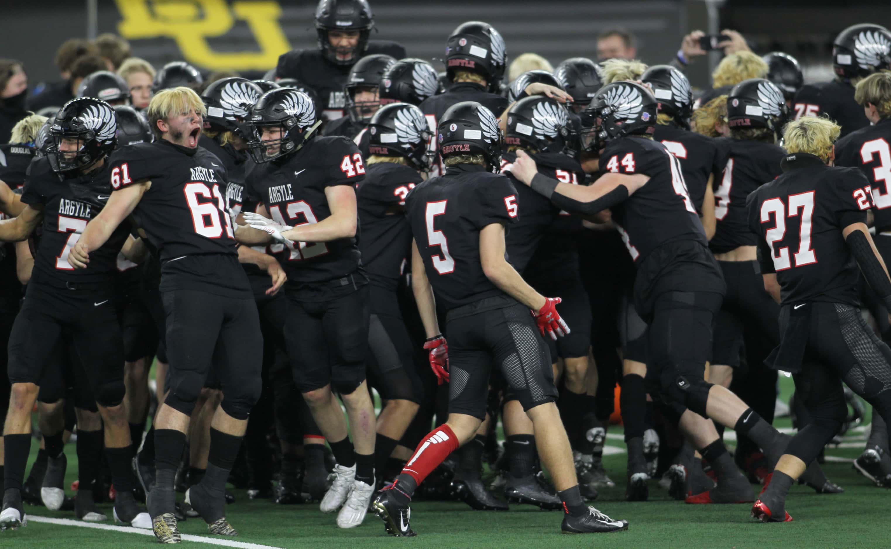 Argyle linebacker Damian Hirschhorn (61), left, lets out a yell as he celebrates with...
