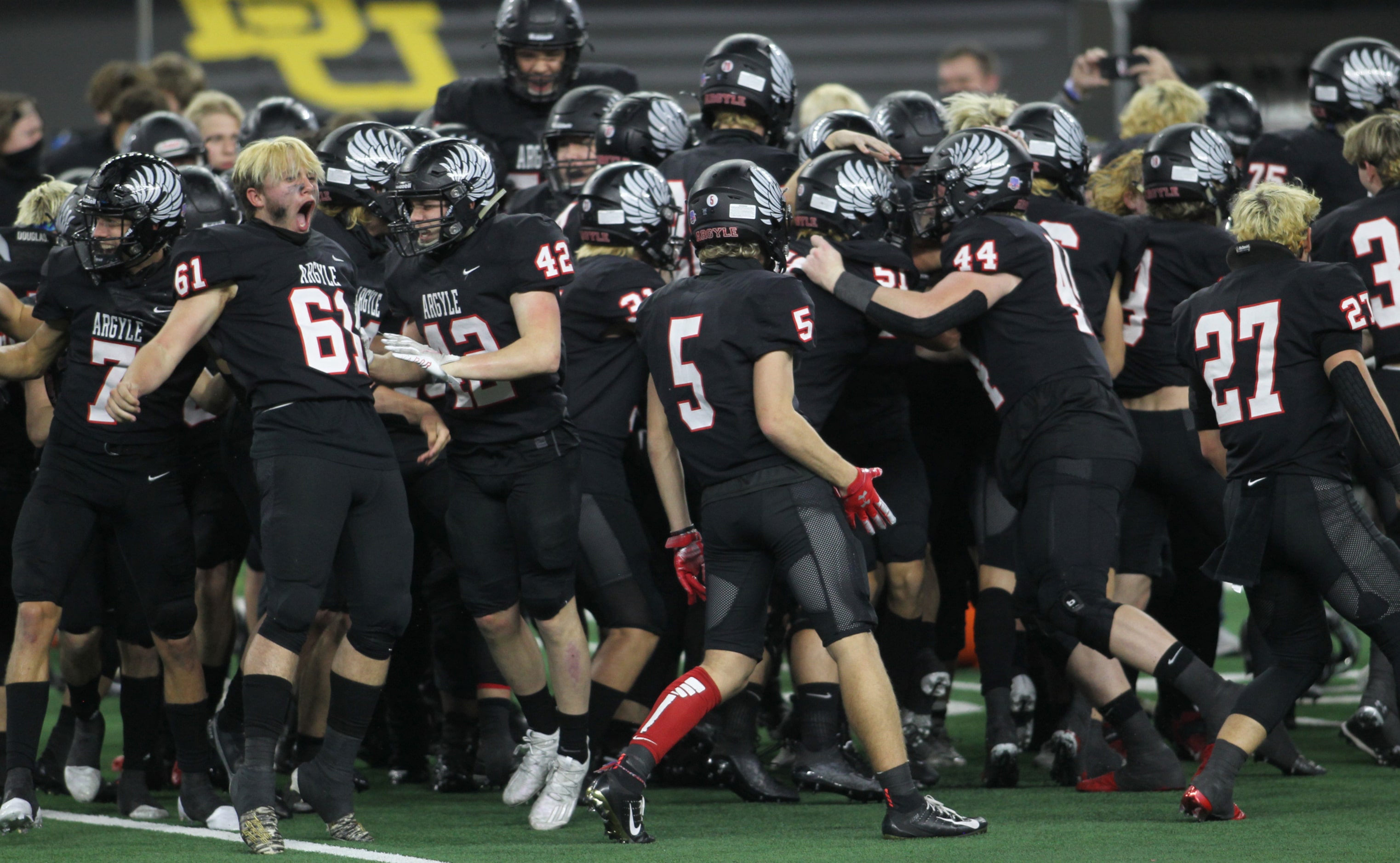 Argyle linebacker Damian Hirschhorn (61), left, lets out a yell as he celebrates with...