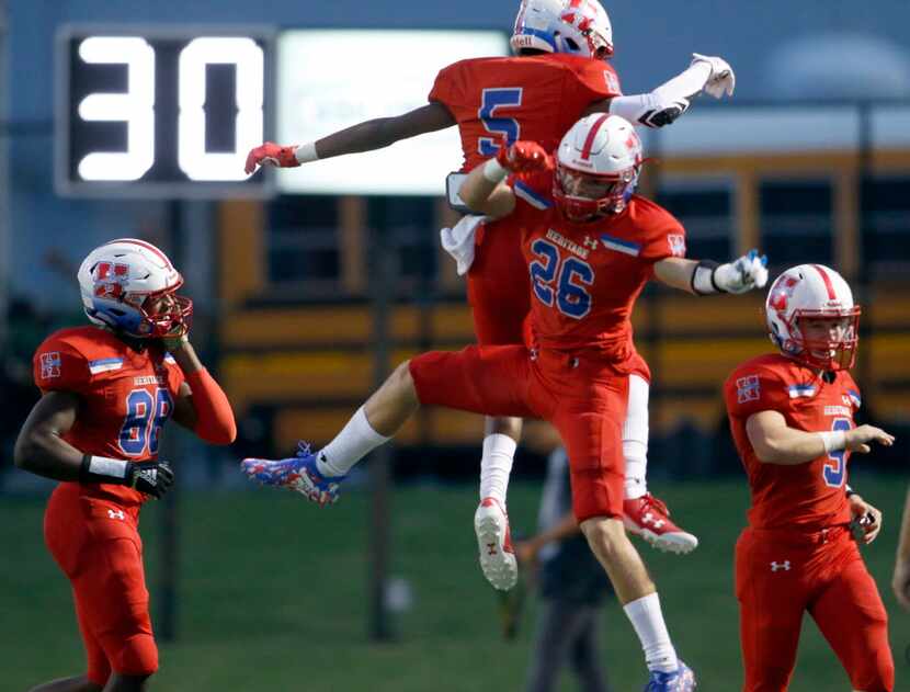 Midlothian Heritage running back Dre Washington (5) takes to the air to celebrate with...