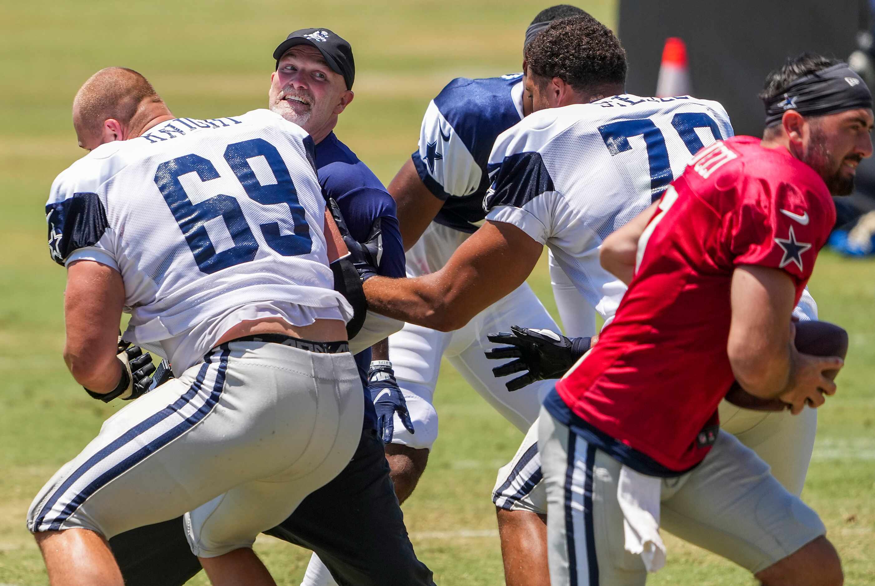Dallas Cowboys defensive coordinator Dan Quinn lines up at defensive lineman and works...