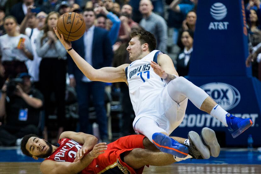 Dallas Mavericks forward Luka Doncic (77) falls to the ground as New Orleans Pelicans guard...