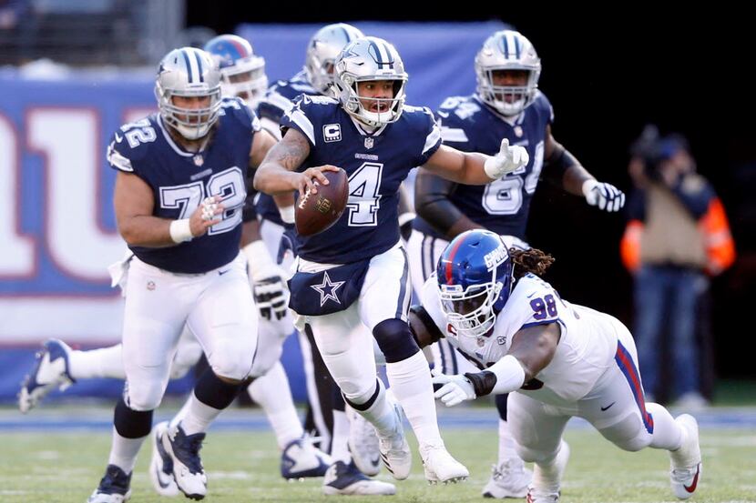 Dallas Cowboys quarterback Dak Prescott (4) scrambles as he evades New York Giants defensive...