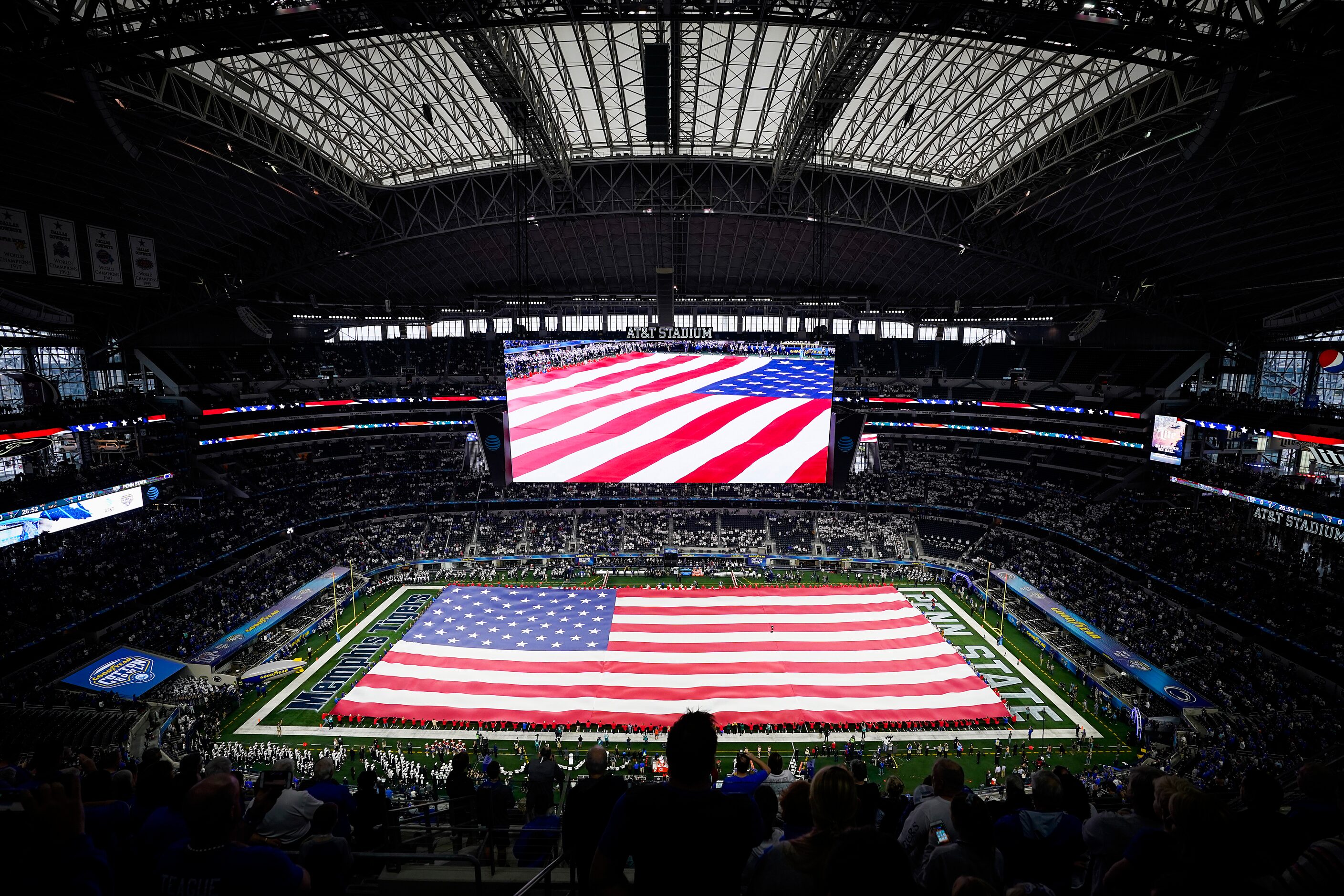 A flag covers the field during the national anthem before the Goodyear Cotton Bowl Classic...