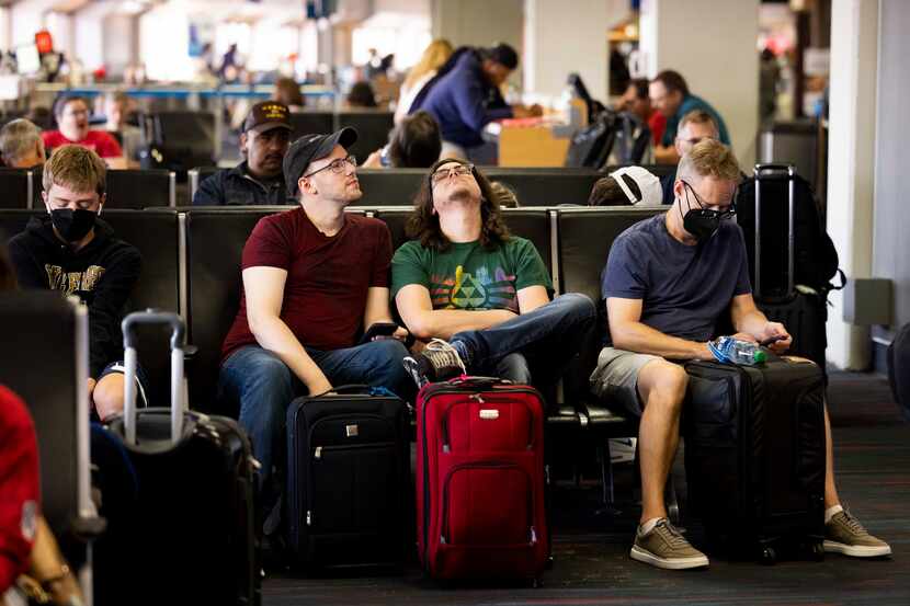 Tommy McCarver (center left) and husband Kyle Murell (center right) wait for their flight to...