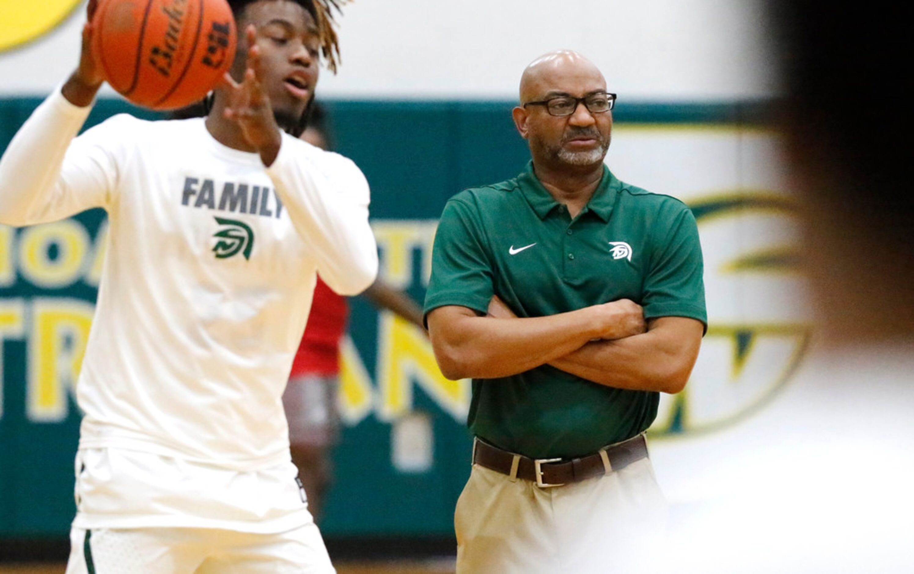 Newman Smith High School head coach Percy Johnson watches his team warm up during the first...