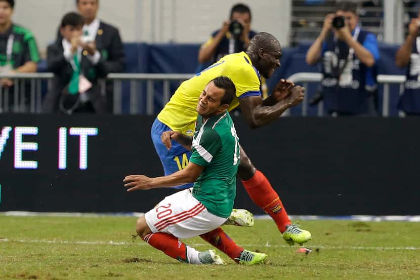 Mexico's Luis Montes collides with Ecuador's Segundo Castillo, rear, as the two were...