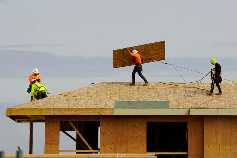 Work is done on the roof of a building under construction in Sacramento, Calif., on March 3,...