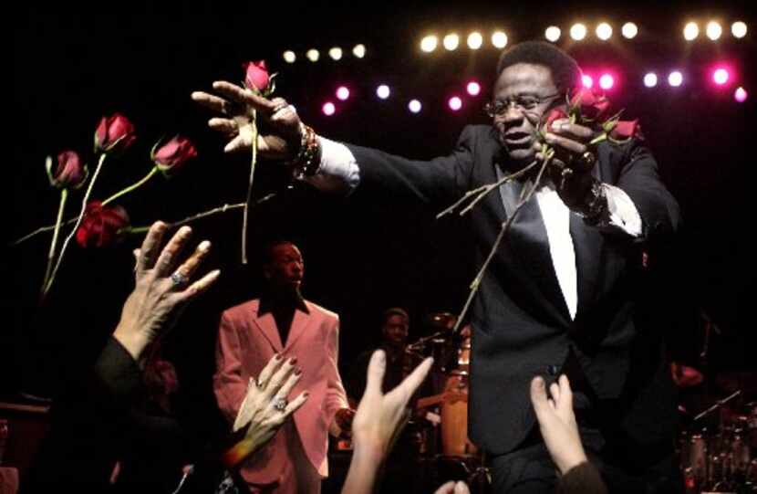 R&B singer Al Green tosses fresh cut roses to ladies in the audience during his opening...