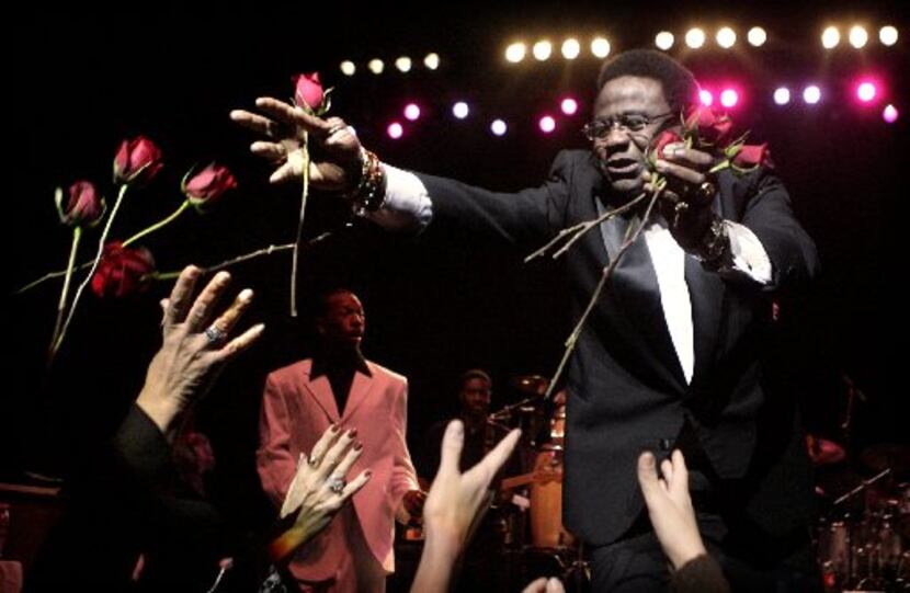 R&B singer Al Green tosses fresh cut roses to ladies in the audience during his opening...