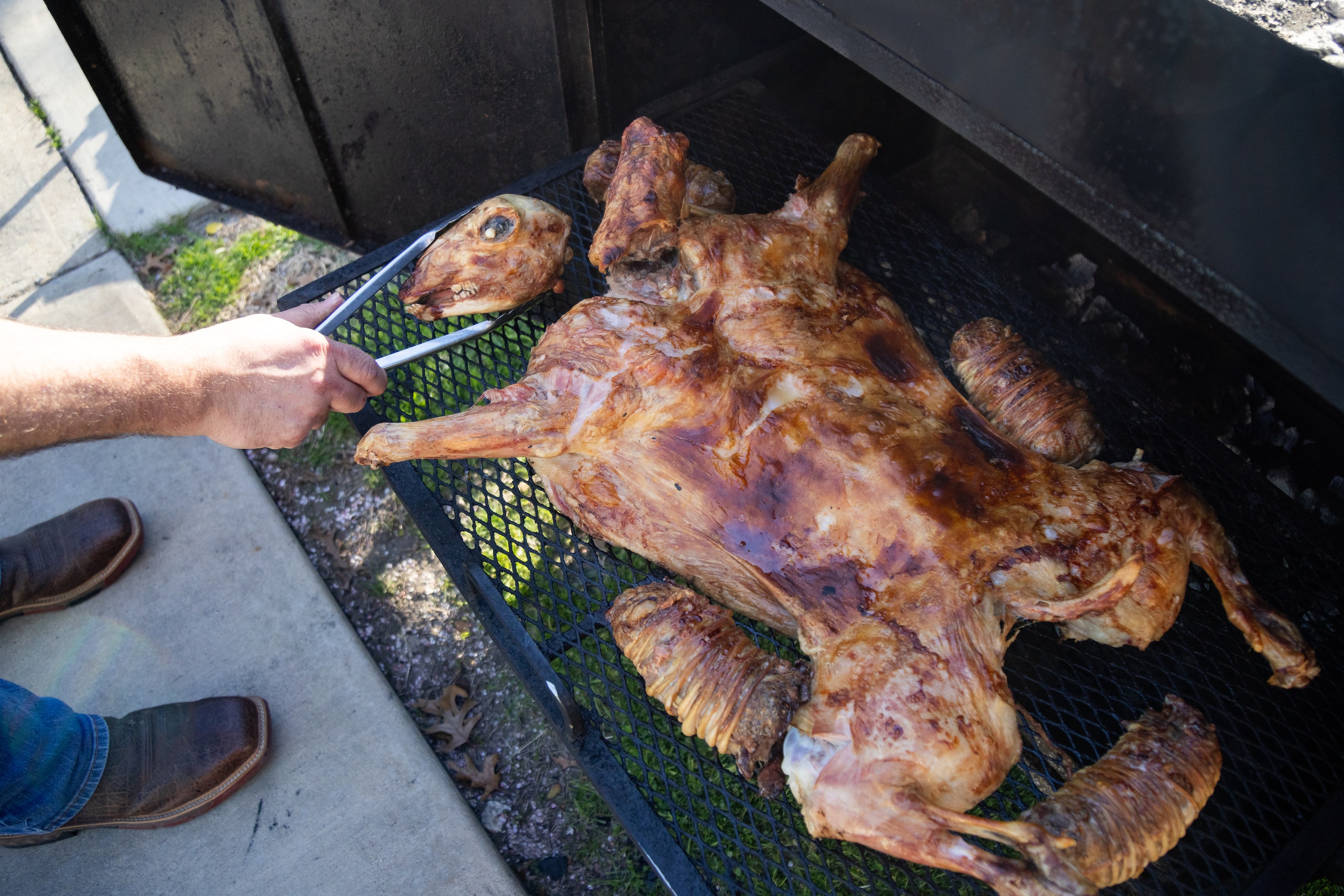 Montemayor flips over the head of the cabrito as it’s cooking al ataud.