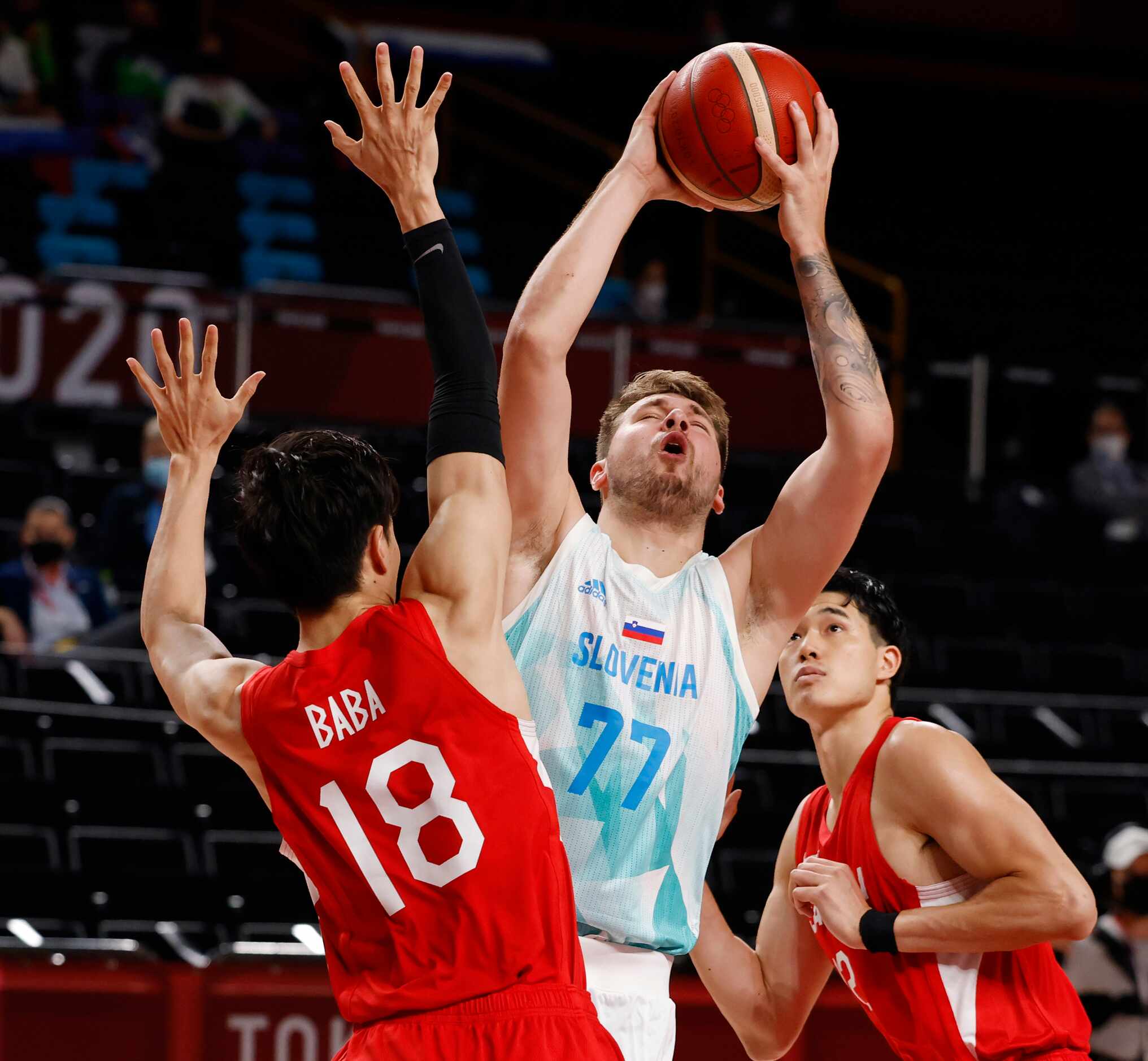 Slovenia’s Luka Doncic (77)  draws the foul as he is defended by Japan’s Yudai Baba (18) and...