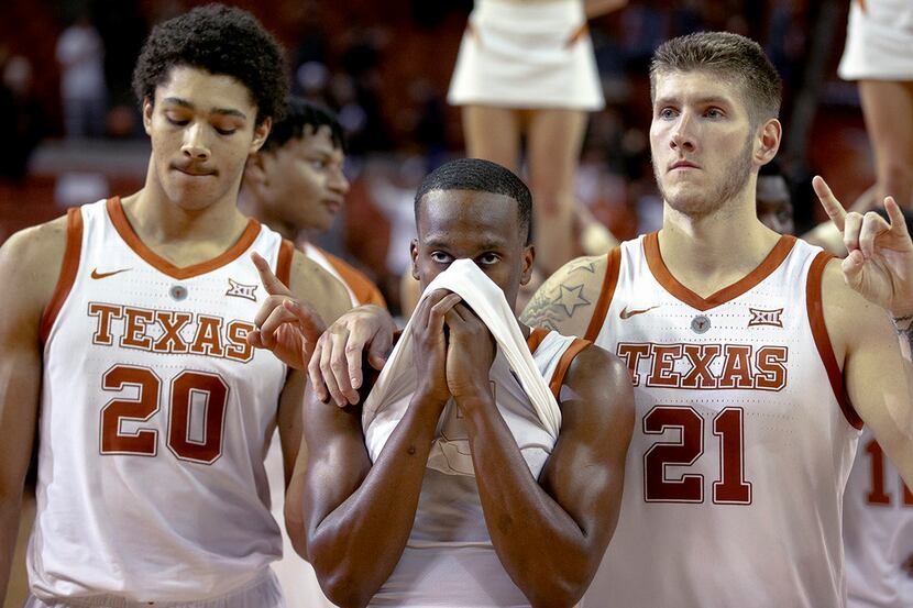 Texas guard Matt Coleman III (2) covers his face while standing for the playing of "The Eyes...