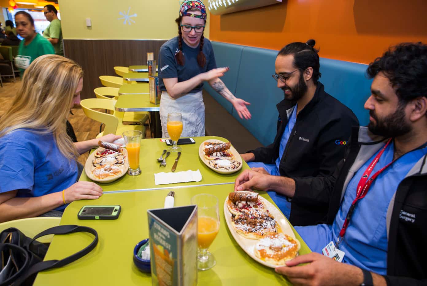 Server Kaitlin Egan delivers Pancake Flights to customers at Snooze: an AM Eatery on...