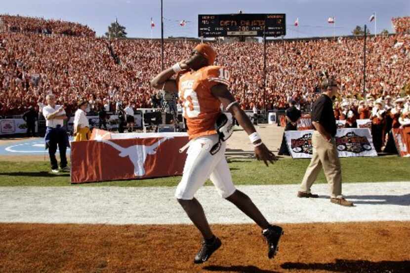 University of Texas running back Ricky Williams (11) is chased by excited ball boy as he...