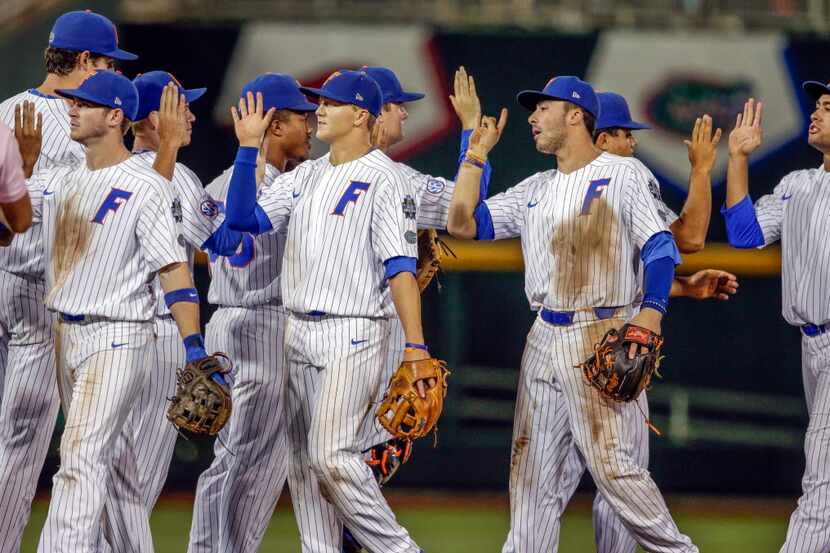 Florida players including Jonathan India, second right, exchange high-fives following an...