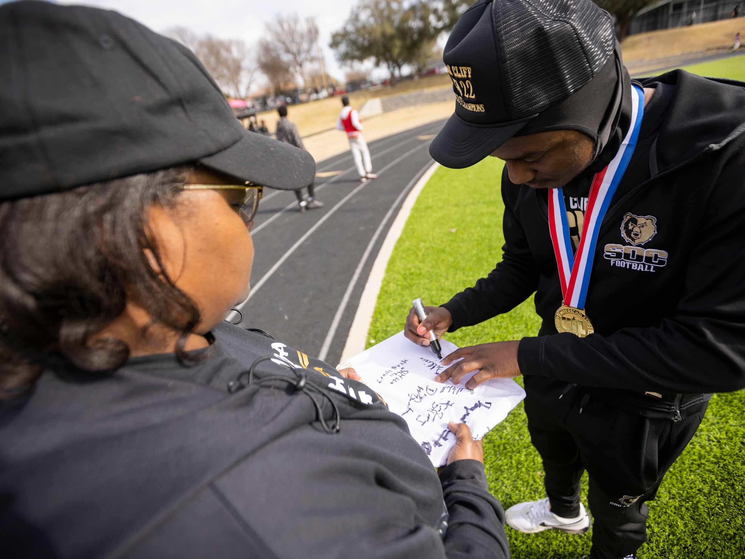 Former assistant principal Marsha Potts receives an autograph from South Oak Cliff Golden...