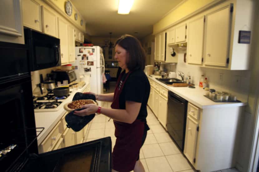 Karen Kern places miniature pies in jars in her Garland home. She lost her catering job last...