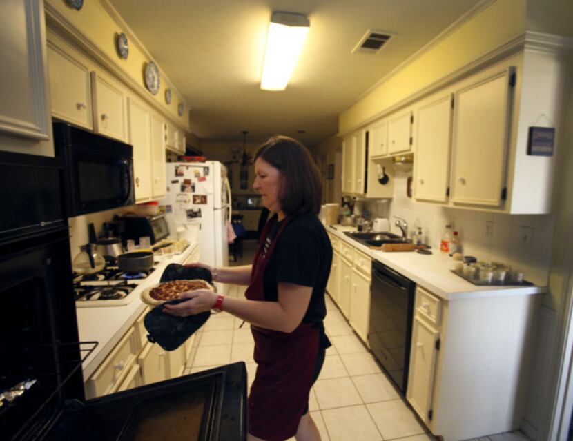 Karen Kern places miniature pies in jars in her Garland home. She lost her catering job last...