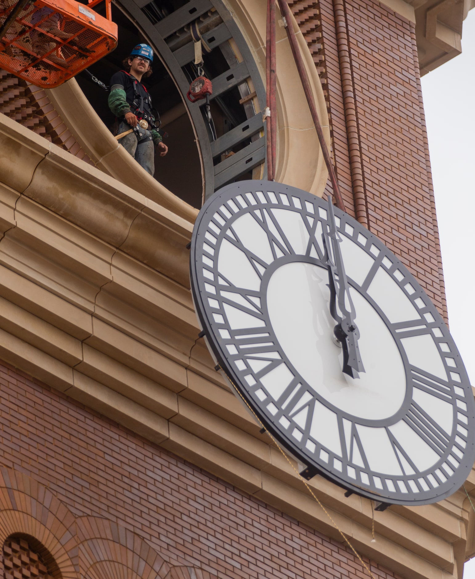 Workers from MEI Rigging & Crating work to install a 12-foot glass clock on the Grapevine...