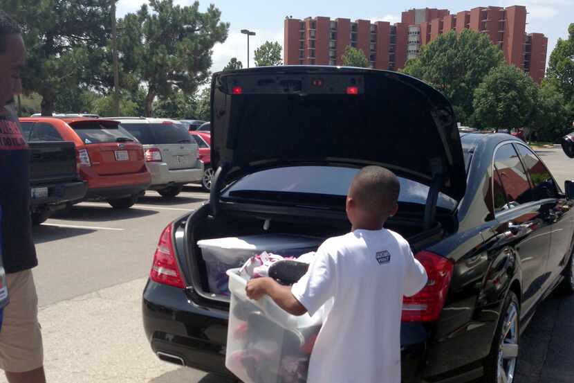Rowlett resident Jay Fair loads 82 pairs of shoes into his family's car. Fair collected the...