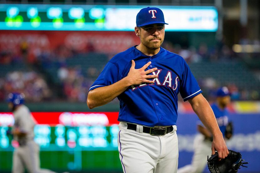 Texas Rangers starting pitcher Matt Moore heads for the dugout after recording the final out...
