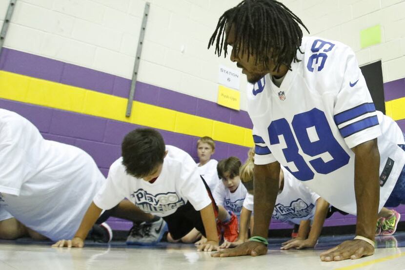 Dallas Cowboys cornerback Brandon Carr joins students at the "Push up" station as he,  the...
