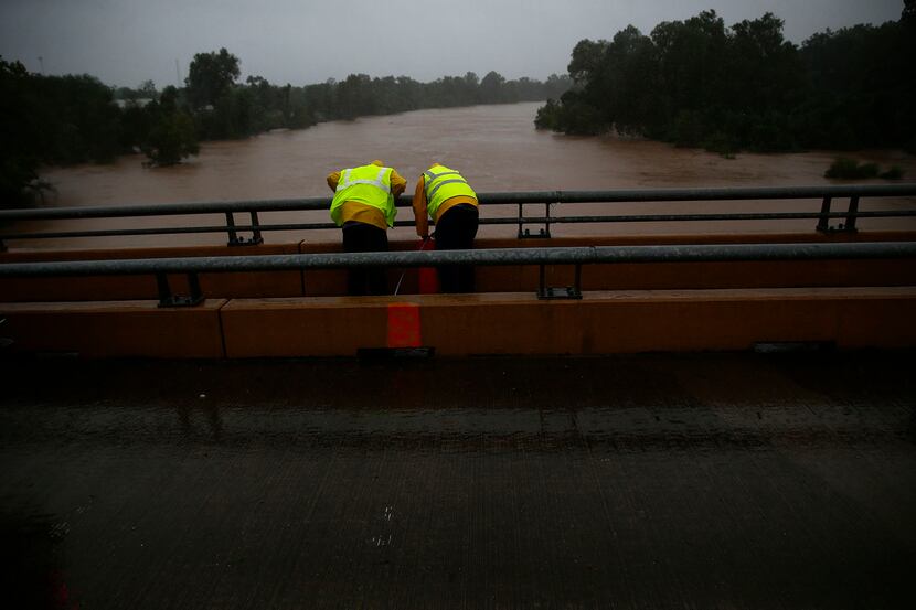 Work crews take measurements of the Brazos River as flooding continues throughout the...