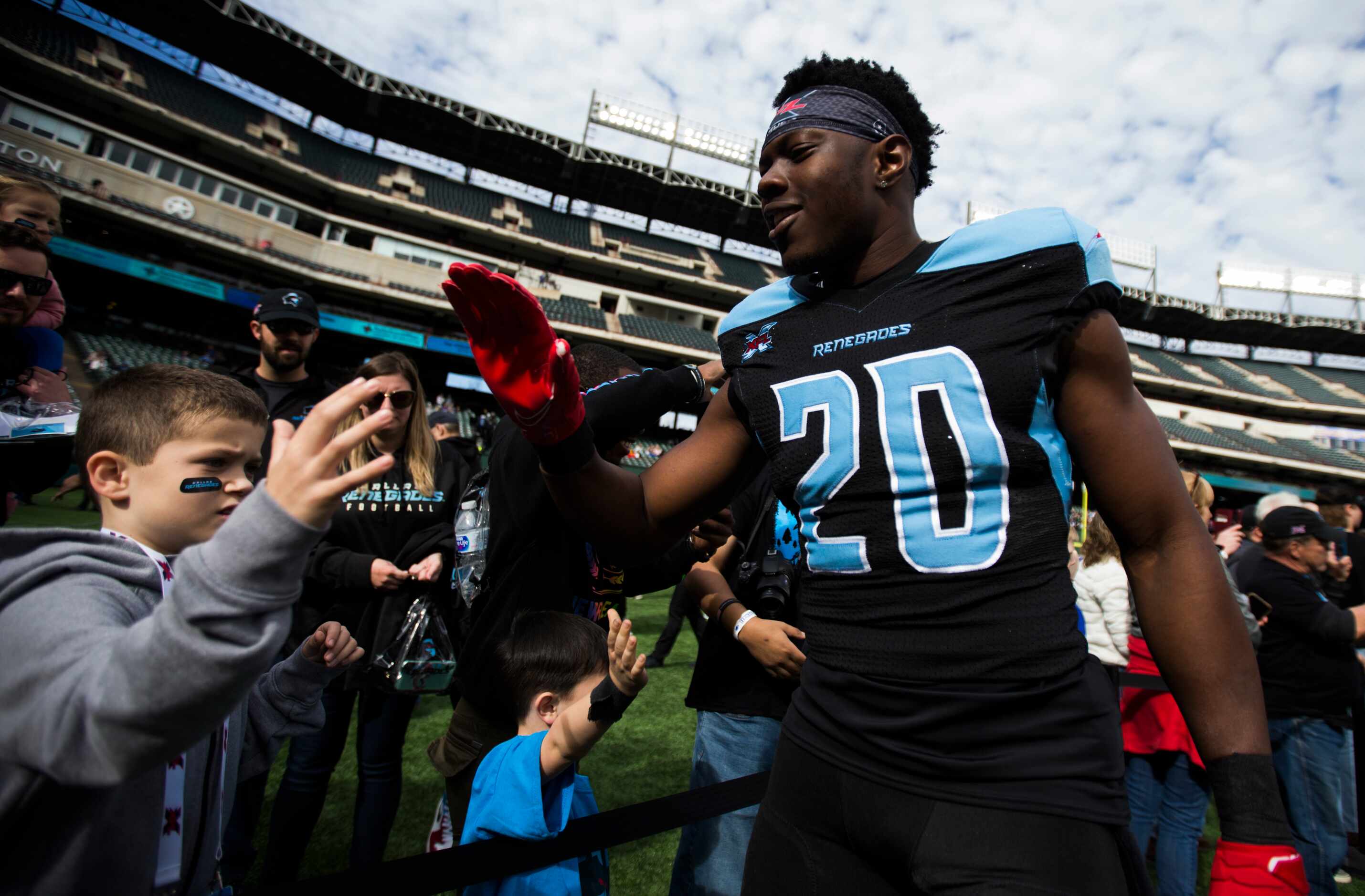 Dallas Renegades safety Tenny Adewusi (20) high-fives a fan before an XFL game between the...