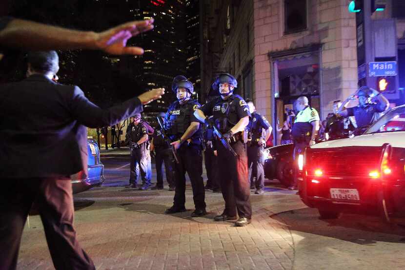 Organizers attempted to move protesters out of the street while Dallas police officers get...