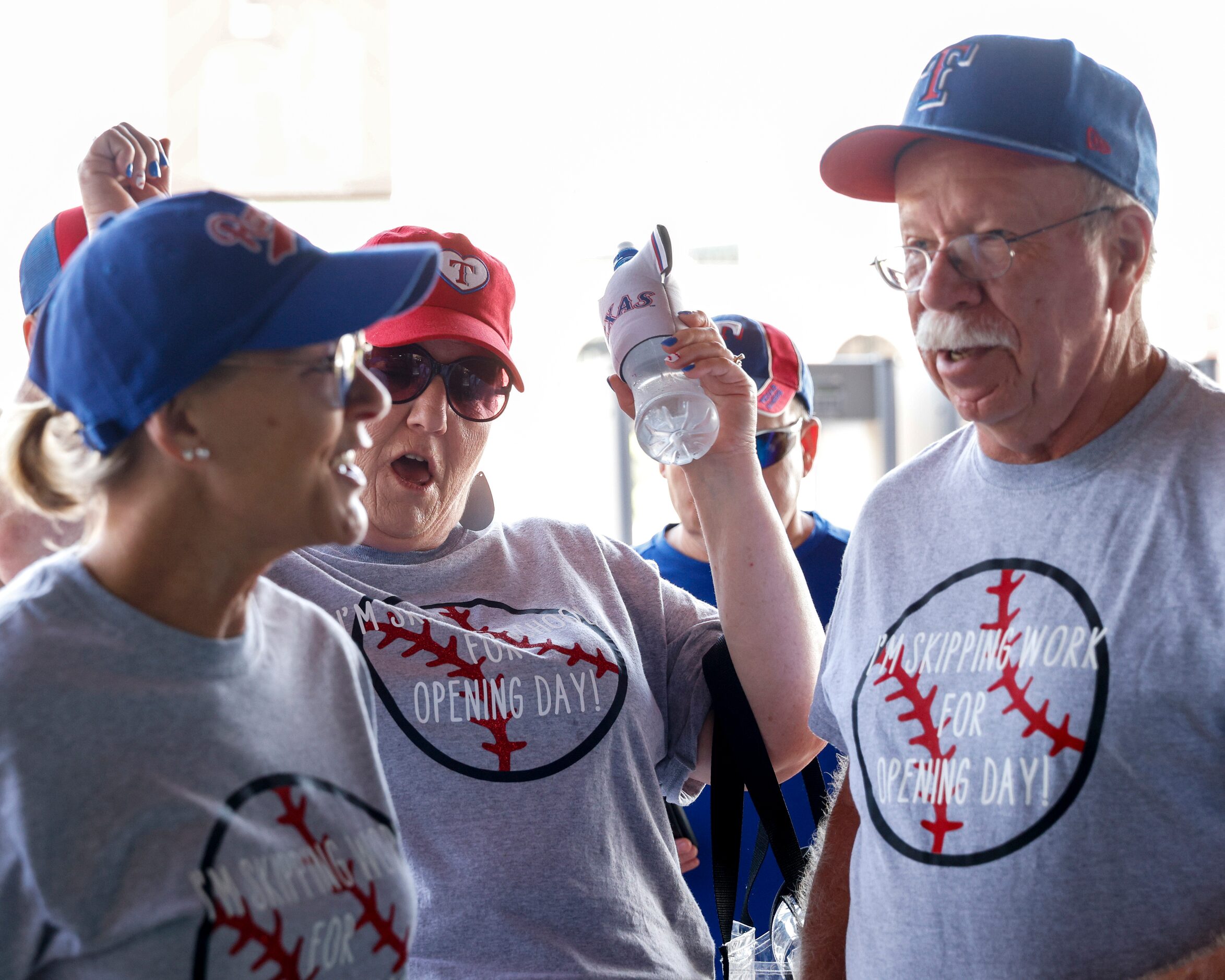 Suzanne Sauls (center) pumps her fists as she makes her way into the ballpark alongside her...