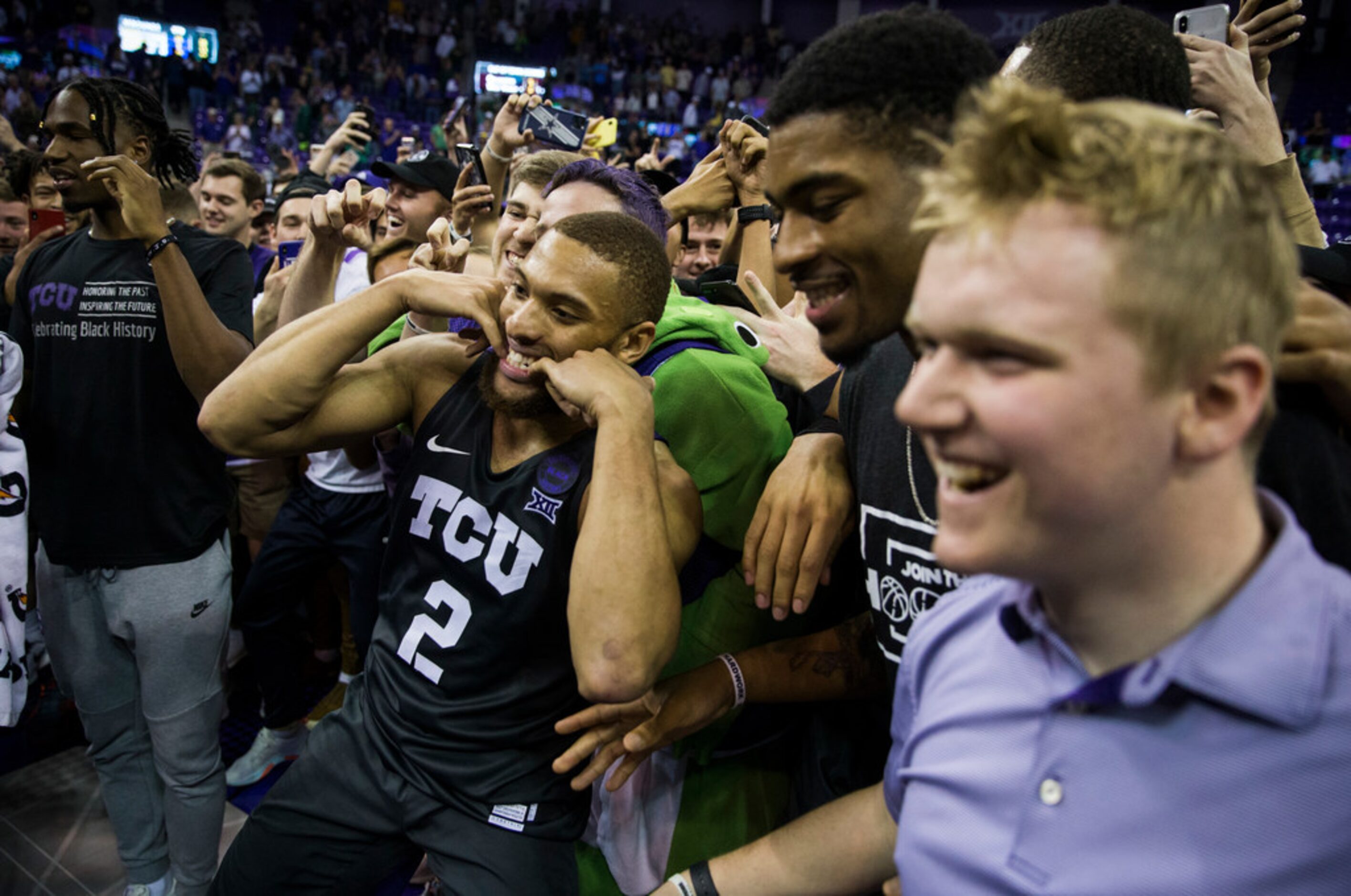 TCU Horned Frogs guard Edric Dennis (2) celebrates after fans rush the court because of a...