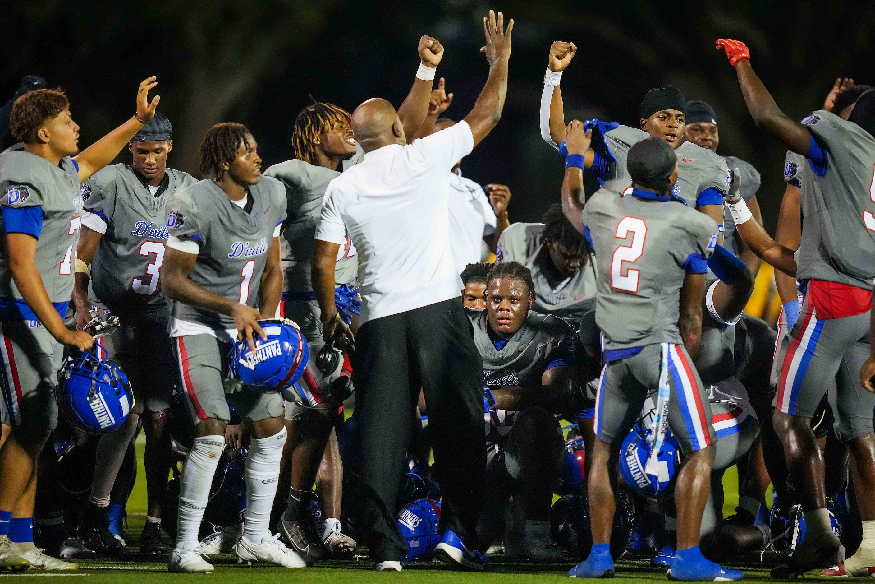 Duncanville players celebrate around head coach Reginald Samples after a victory over St....