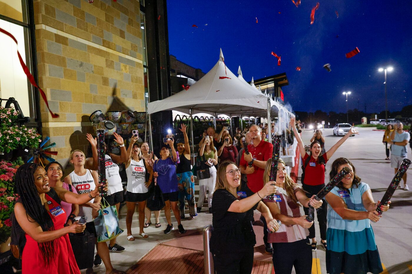 Customers and employees cheer as confettis explode during the opening day of H-E-B on...