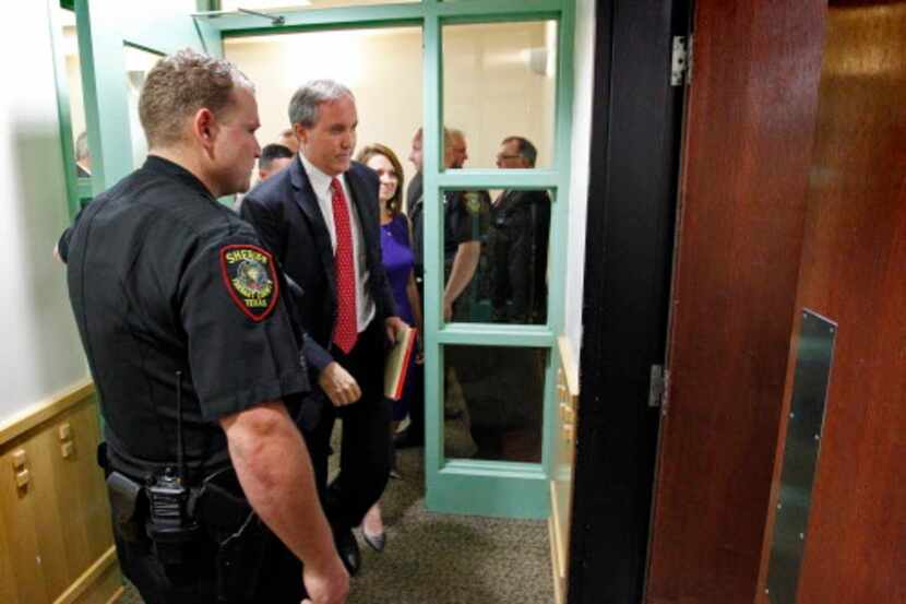  Texas Attorney General Ken Paxton, second left, leaves court after a hearing on Paxton's...