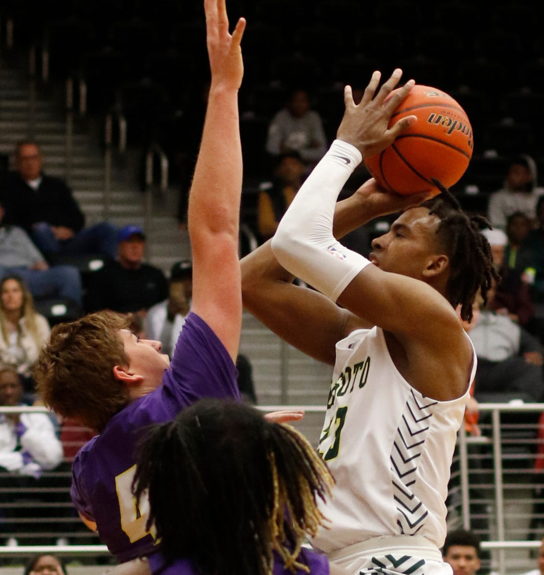 DeSoto post Tavion Carroll (23) shoots over the defense of Richardson forward Gannon Parker...