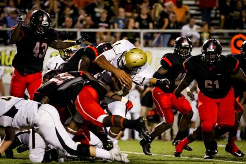 
Plano East quarterback Miklo Smalls (1) is swarmed by the Lake Highlands defense as...